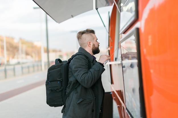 Portrait of man choosing fast food in food truck in the street meal food industry and streetfood