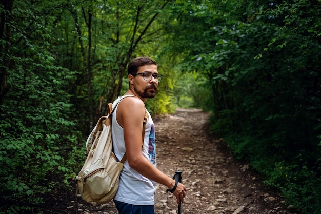 Portrait of a man hiker walking on the trail in the woods