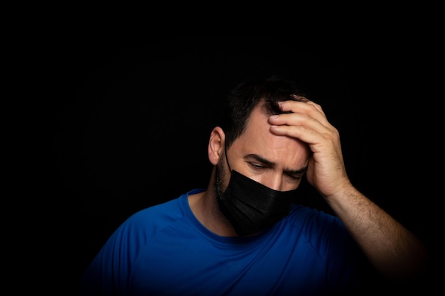 Photo portrait of man making face against black background