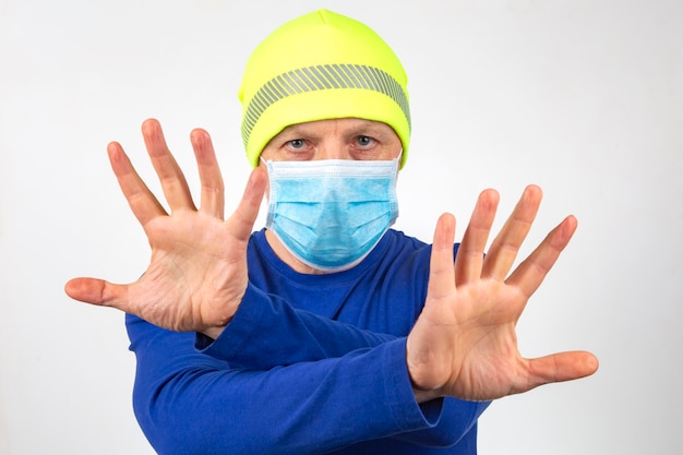 Photo portrait of a man in a medical mask with raised hands. clean hands and quarantine