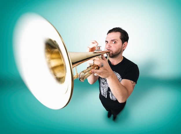 Photo portrait of man playing trumpet over green background