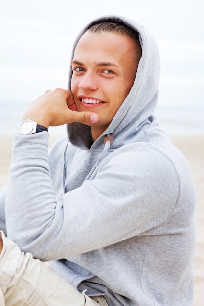 Portrait of man smiling and sitting on the beach