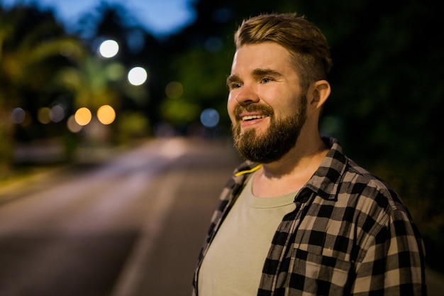 Portrait of man standing in night city street with copy space and place for text Confident happy guy Closeup portrait