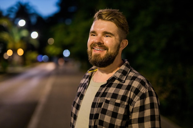 Portrait of man standing in night city street with copy space and place for text Confident happy guy Closeup portrait