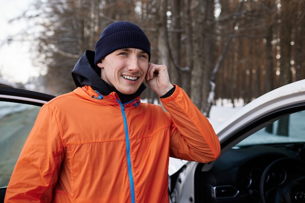 Portrait of a man stretching in the park on a beautiful snowy winter day, preparing for running