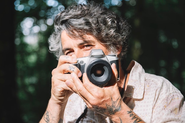 Portrait of a man taking a photo of the viewer with a vintage camera