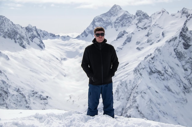 Portrait of a man on top of a snowy mountain.