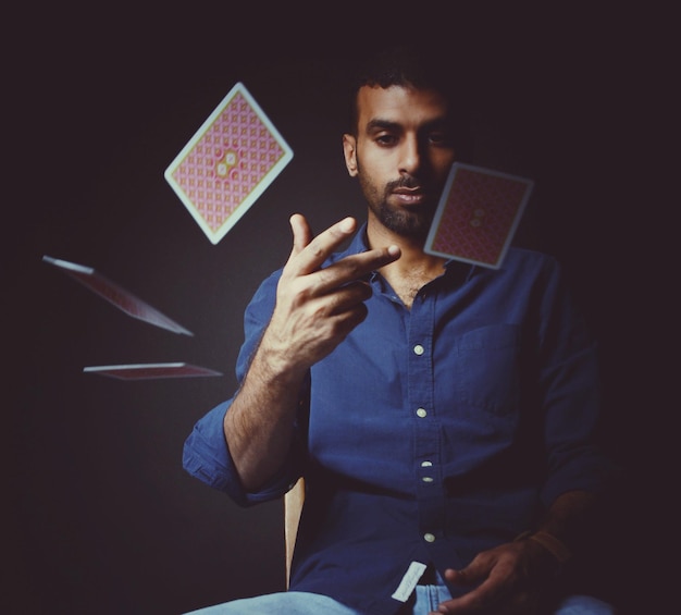 Portrait of man using smart phone against black background