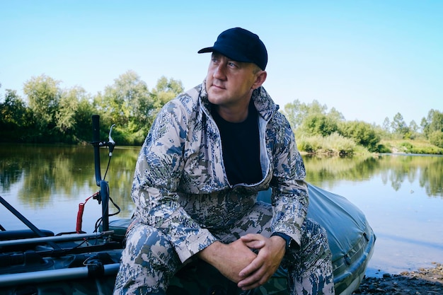 Portrait of a man on vacation in nature riding an airboat on the river in hunter's clothes