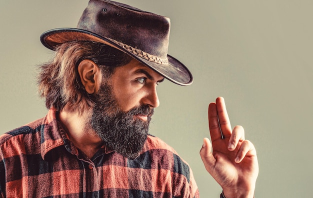 Portrait of man wearing cowboy hat gun Portrait of a cowboy West guns Portrait of a cowboy American bandit in mask western man with hat