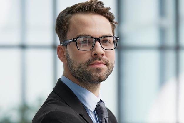 Portrait man wearing spectacles and looking at camera indoor