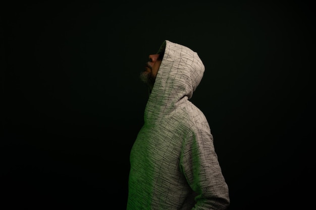 Photo portrait of man wearing sunglasses and hooded sweatshirt looking up