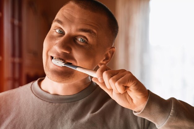 Portrait of a man with blue eyes cleaning teeth