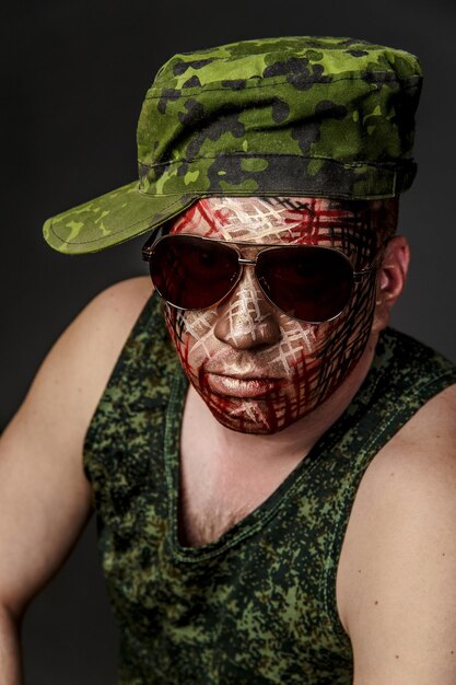 Photo portrait of man with face paint wearing sunglasses and cap