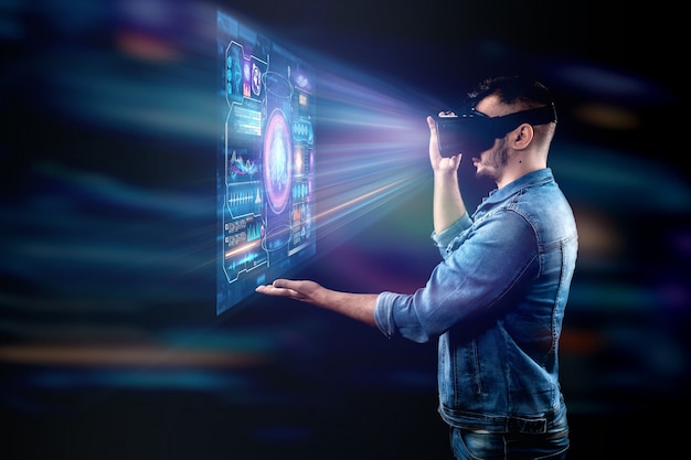 Portrait of a man with glasses of virtual reality, vr, interacts with a virtual screen