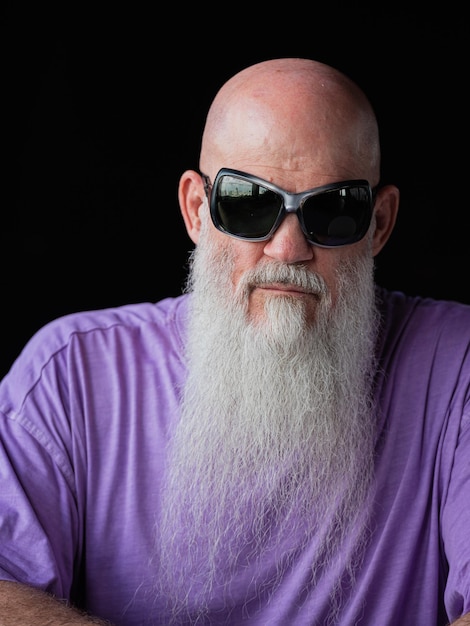 Portrait of man with long gray beard wearing purple tshirt and sunglasses closeup shot