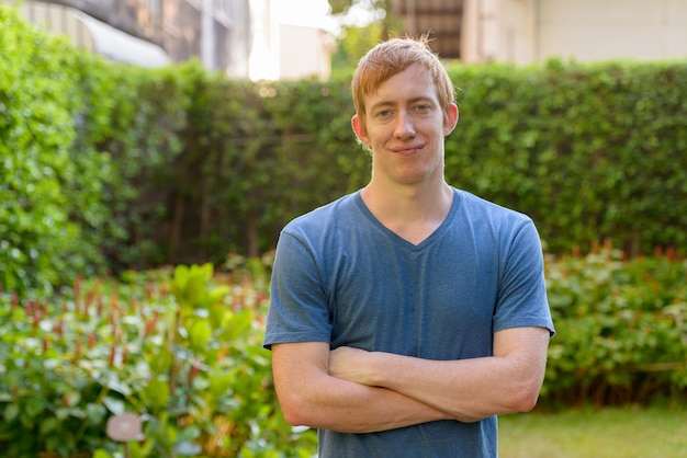 Portrait of man with red hair looking confident in the park