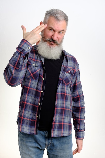 Portrait of mature bearded man pointing fingers to temple