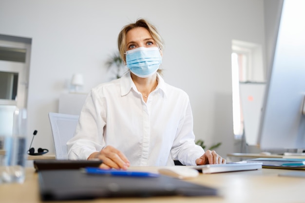 Portrait of a mature business woman in a medical mask