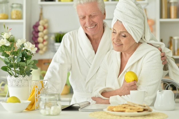 Portrait of mature couple in a bathrobe at kitchen