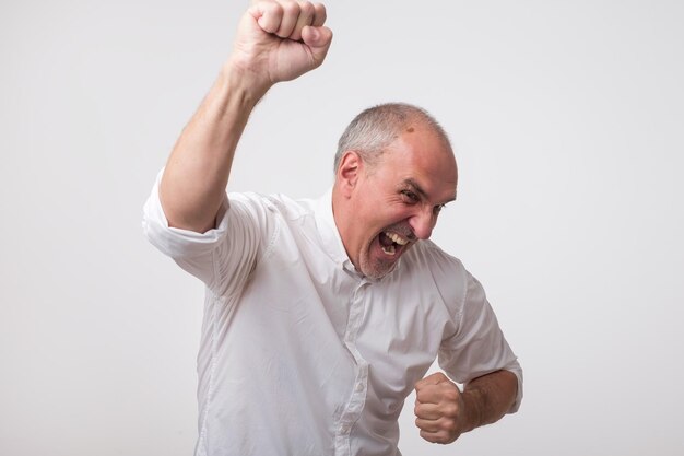 Portrait of mature european man with fists up He is celebrating winning