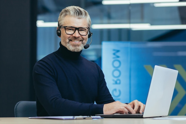 Portrait of mature gray haired businessman man in glasses smiling and looking at camera senior boss