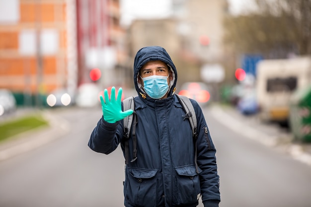 Portrait of Mature Man, saying no to coronavirus infection with wearing medical surgical blue face mask