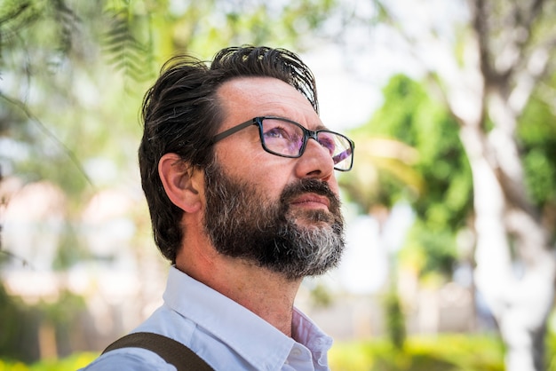 Portrait of a mature man with eyeglasses looking pensive.