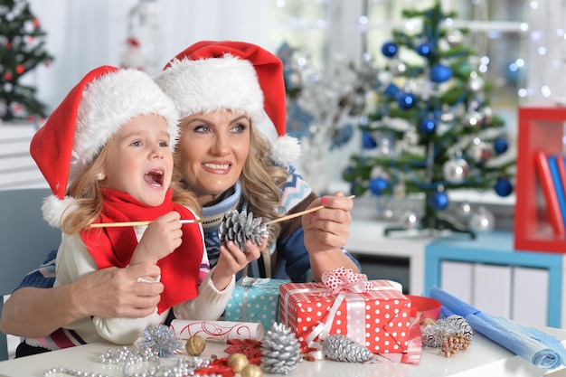 Portrait of mature woman and child girl preparing for Christmas