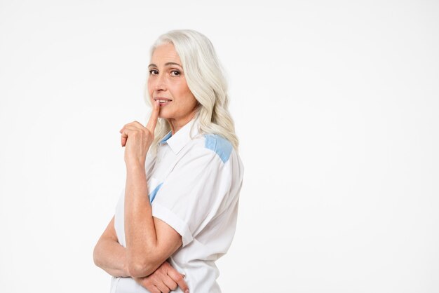 Portrait of a mature woman showing silence gesture