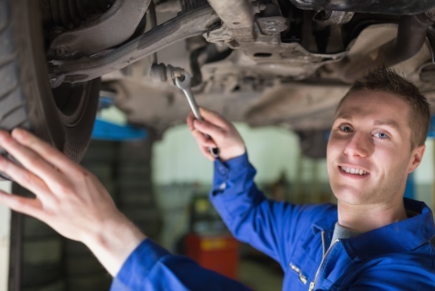 Portrait of mechanic working under car