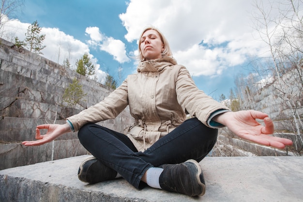 Portrait of a meditating blonde outdoors 