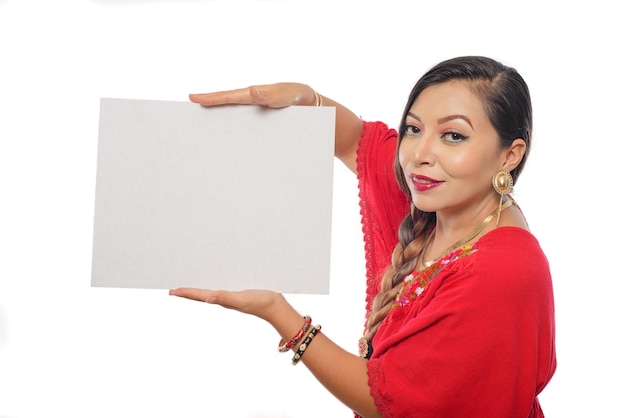 Portrait of Mexican woman in traditional dress holding a blank poster. White background.