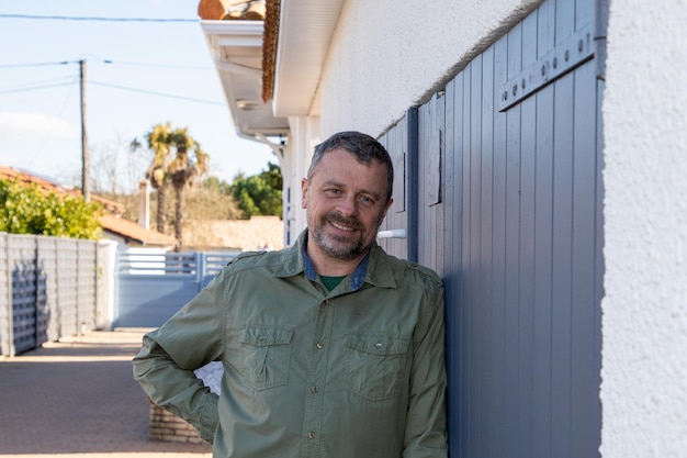 Portrait of middle aged beard Man smiling in front home