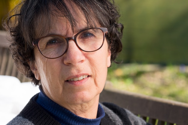 Portrait of a middle-aged brunette woman with eyeglasses, outdoor