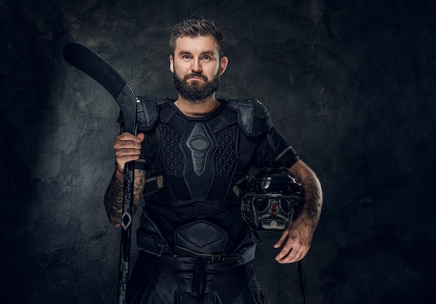 Portrait of middle aged handsome man with hockey stick and uniform.