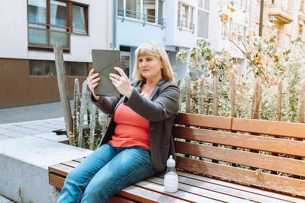 Portrait middle aged woman chatting by video call outdoors