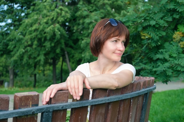 Portrait of a middleaged woman on a bench in a city park