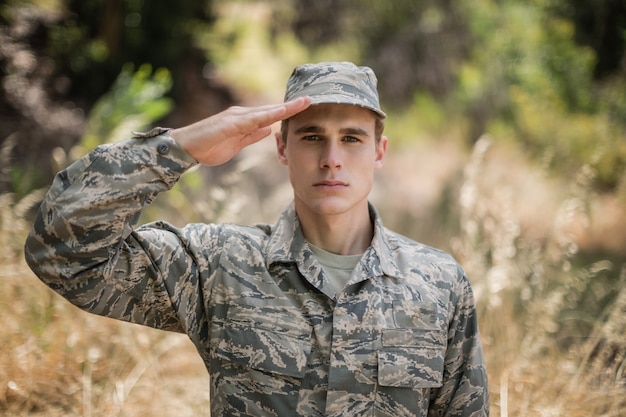 Portrait of military soldier giving salute in boot camp