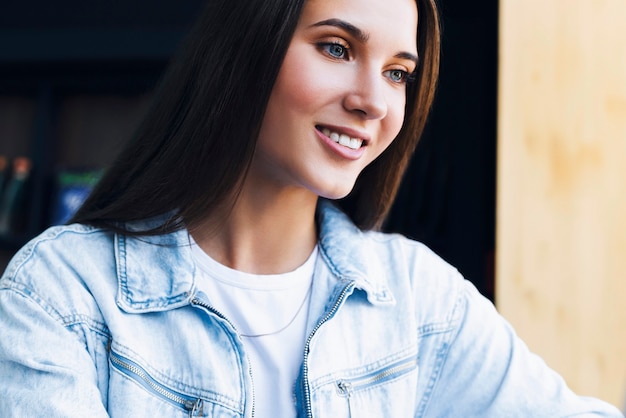 Portrait of millennial girl in denim shirt in comfortable position.