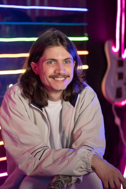 Portrait of millennial man with long hair in neon retro style