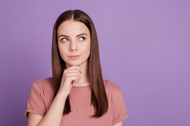 Portrait of minded girl look copyspace think touch chin hands isolated over violet background