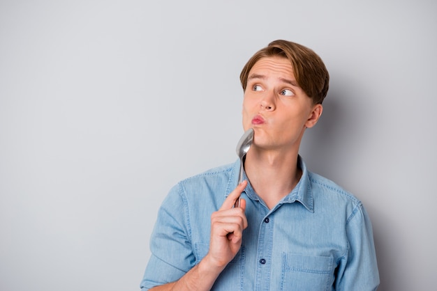 Portrait of minded guy think thoughts look copyspace doubt hold spoon