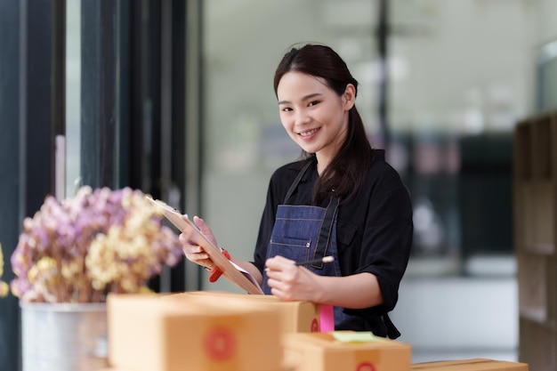 Portrait of modern Asian SME business woman entrepreneur at home office