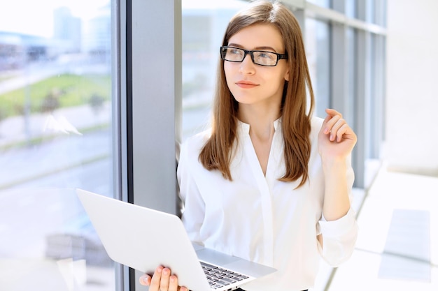 Portrait of modern business woman working with laptop computer in the office copy space area