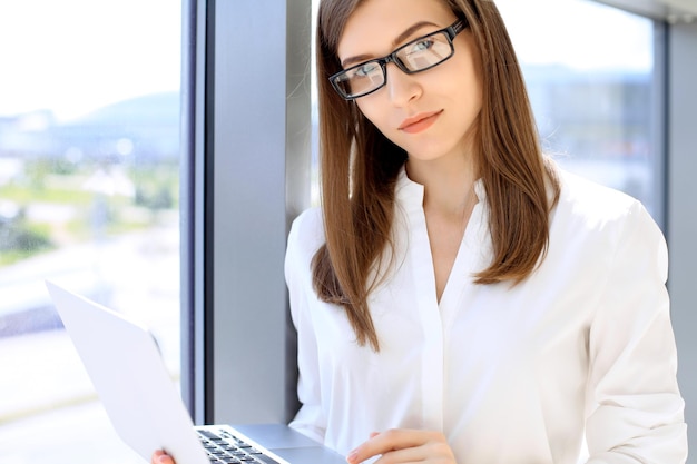 Portrait of modern business woman working with laptop computer in the office copy space area