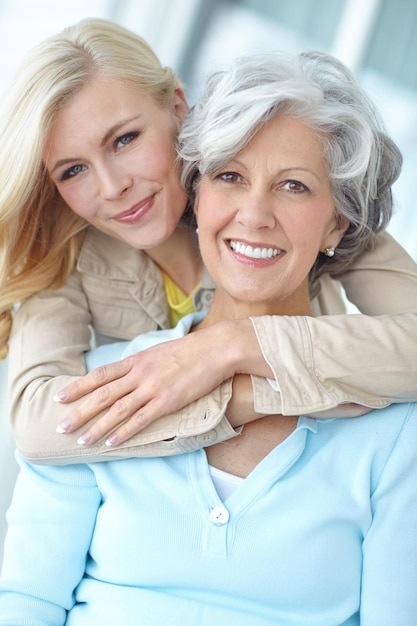 Portrait mom and woman hug in home to relax together with smile love and wellness for affection Mothers day mature and happy daughter bonding in lounge with family parent and support in Germany