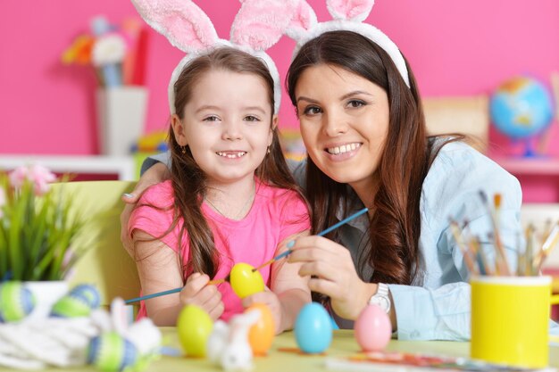 Portrait of mother and daughter decorating Easter eggs