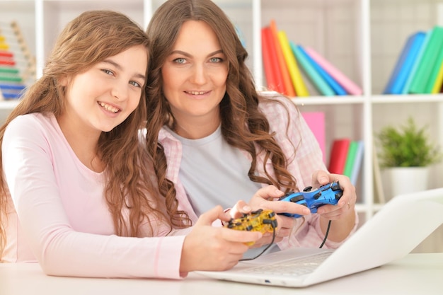 Portrait of a mother and daughter playing video games