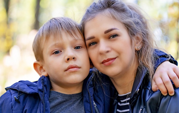 Portrait of mother and her little son on walk in countryside Close up of young woman with child in nature